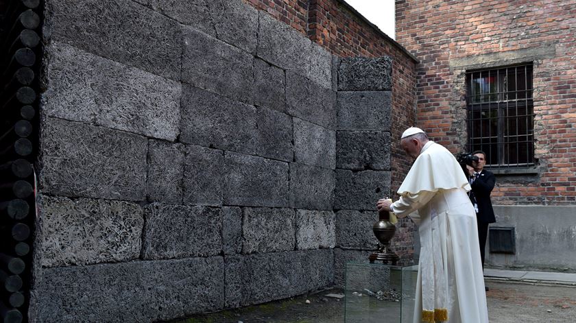 Papa acende vela junto ao muro da morte. Foto: Radek Pietraszka/ EPA