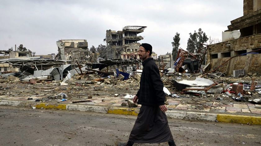 Homem caminha por uma rua destruída de Mossul. Foto: EPA
