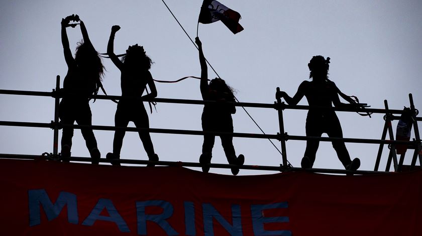 Grupo feminista "FEMEN" exibe uma faixa onde se lê "Marine no poder, Marianne no desespero", em referência à Efígie da República. O grupo fez o protesto junto à igreja de Saint-Martin, a alguns quarteirões da sede de campanha da Frente Nacional. Foto: IAN LANGSDON/EPA