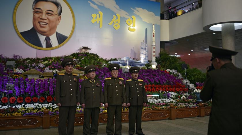 Militares posam em frente ao retrato de Kim Il-sung, durante o Festival das Flores, que abre as comemorações do "Dia do Sol". Uma extensa mostra decorativa enche a sala de exposições "Kimilsungia-Kimjongilia" - duas flores que devem os nomes aos líderes Kim Il Sung e Kim Jong Il.