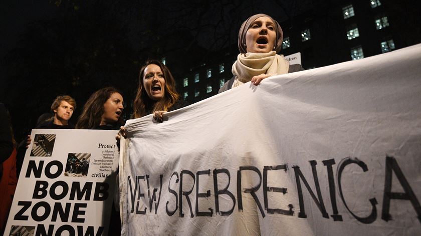 Manifestantes reuniram-se na noite desta terça-feira em frente ao número 10 de Downing Street, Londres, para exigir que a comunidade internacional proteja os civis em Alepo. Nos cartazes apela-se ao fim dos bombardeamentos e alerta-se para o risco de uma repetição do que aconteceu em Srebrenica, na Bósnia e Herzegovina, em 1995. Foto. EPA/FACUNDO ARRIZABALAGA